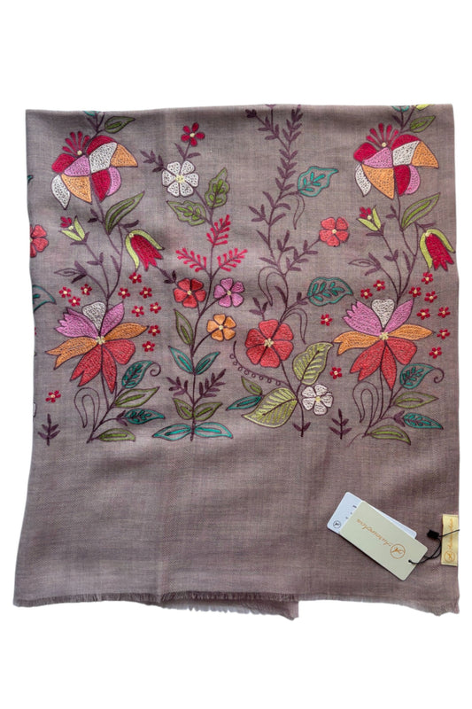 Embroidered floral design on a brown fabric with a tag.