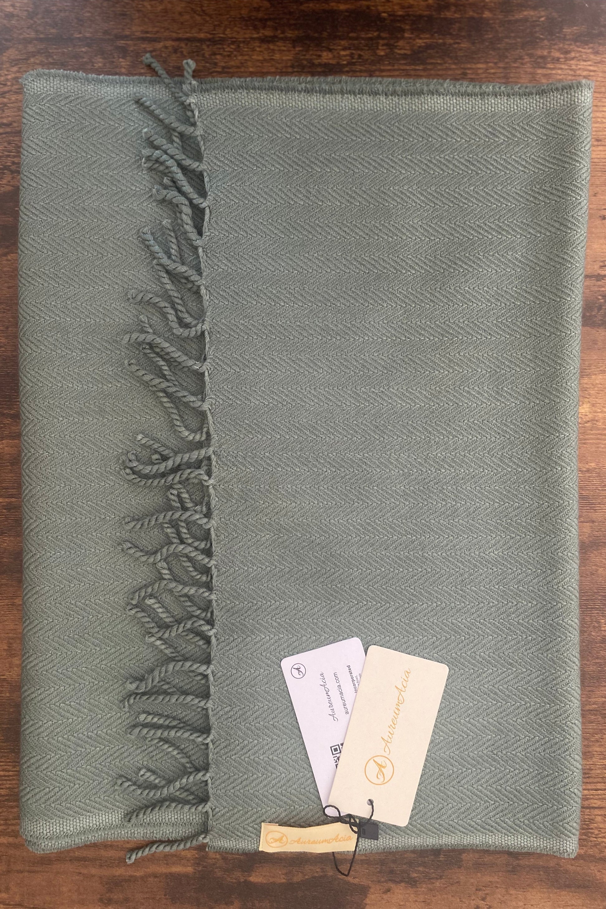 Sage green woollen stole in herringbone pattern with fringes at the end 