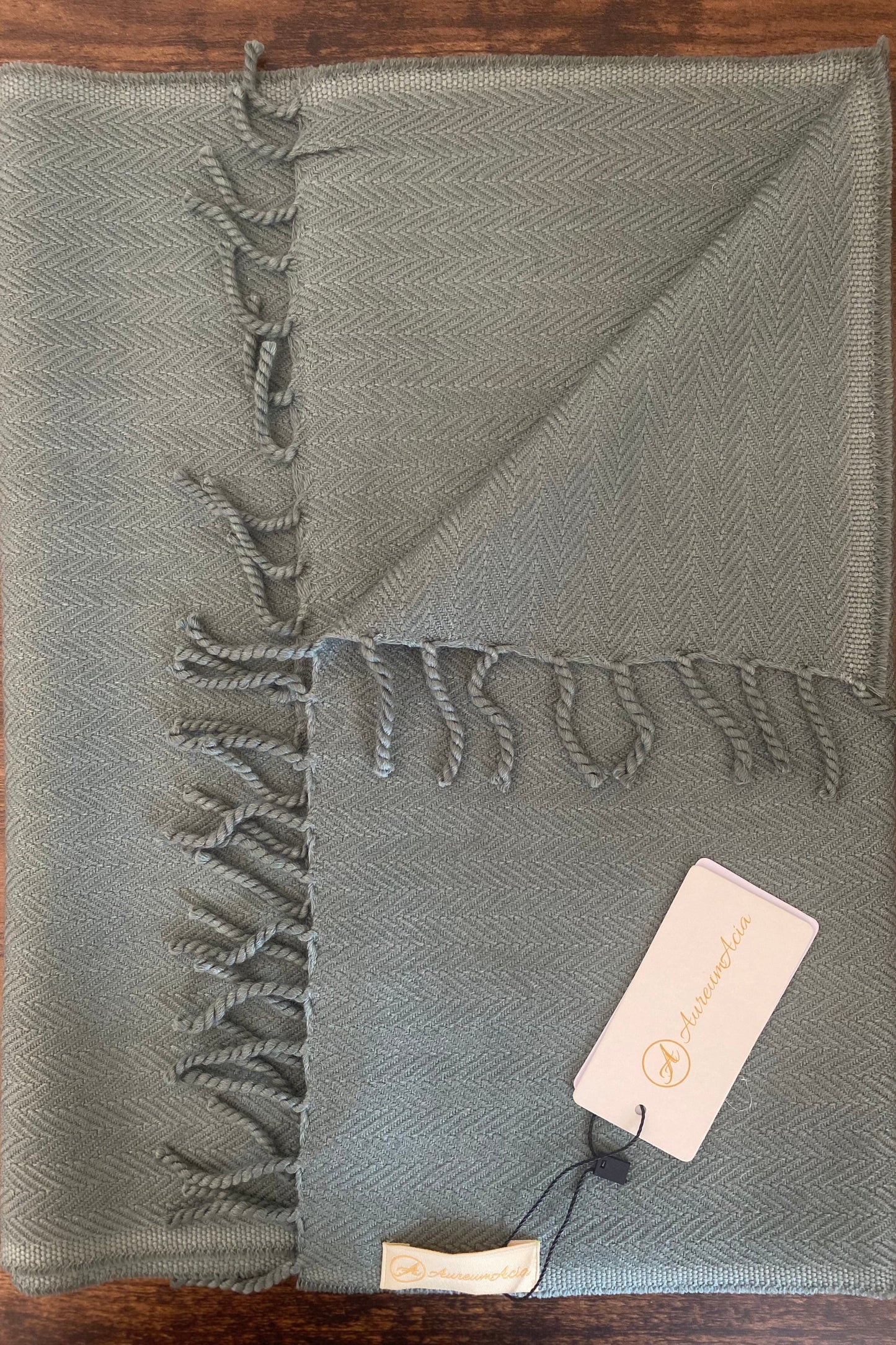 Sage green woollen stole in herringbone pattern with fringes at the end 