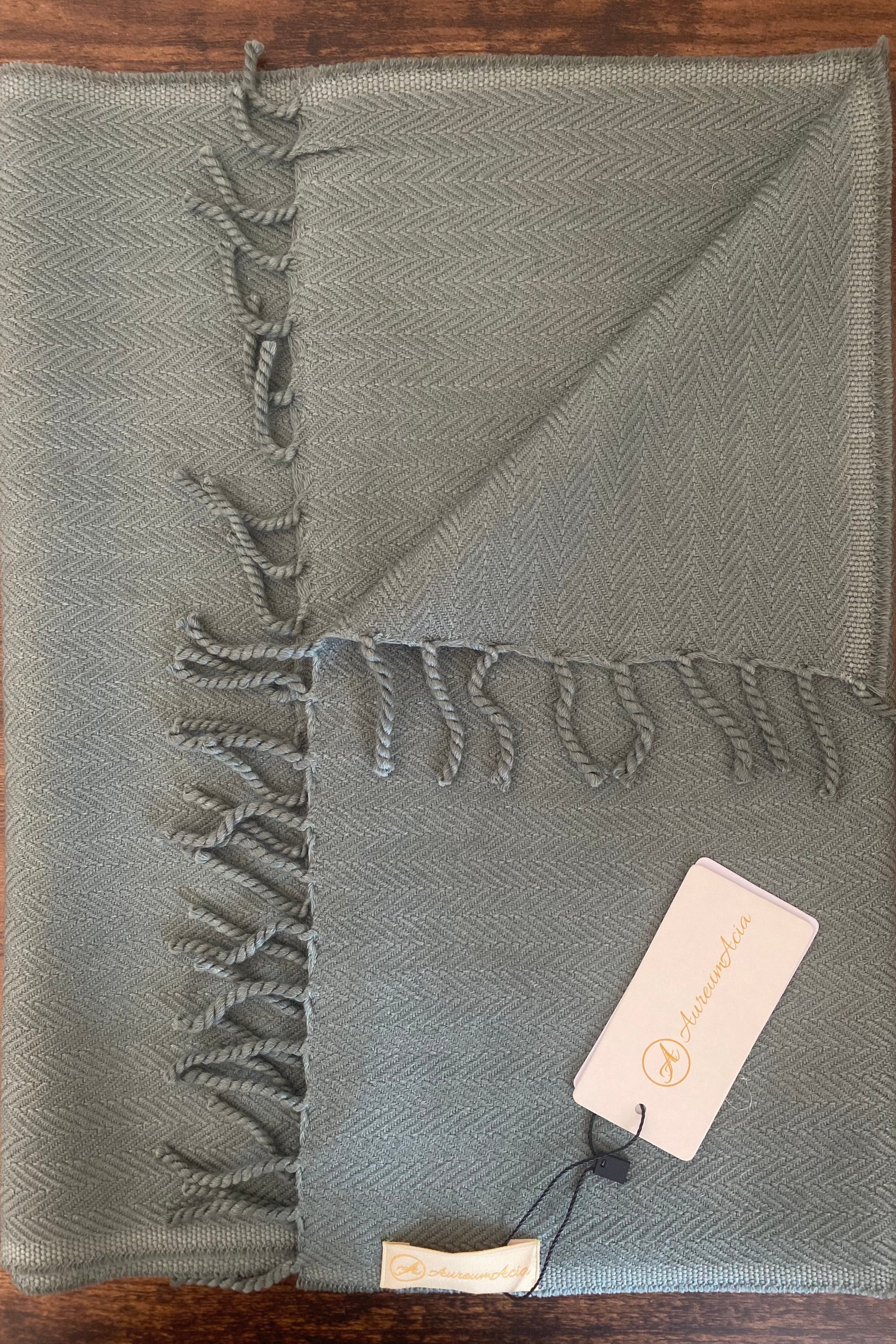 Sage green woollen stole in herringbone pattern with fringes at the end 